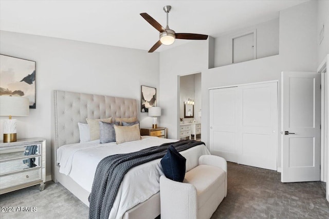 carpeted bedroom with a towering ceiling, ceiling fan, ensuite bath, and a closet