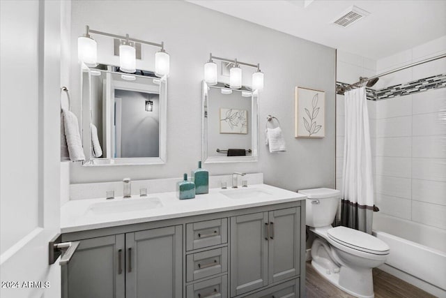 full bathroom with hardwood / wood-style floors, shower / bathtub combination with curtain, toilet, and dual bowl vanity