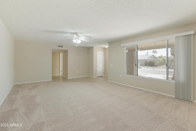 carpeted spare room featuring a textured ceiling and ceiling fan