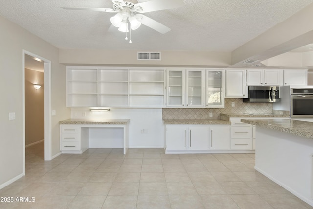 kitchen with appliances with stainless steel finishes, tasteful backsplash, a textured ceiling, ceiling fan, and white cabinetry