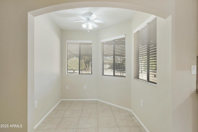 tiled spare room with ceiling fan