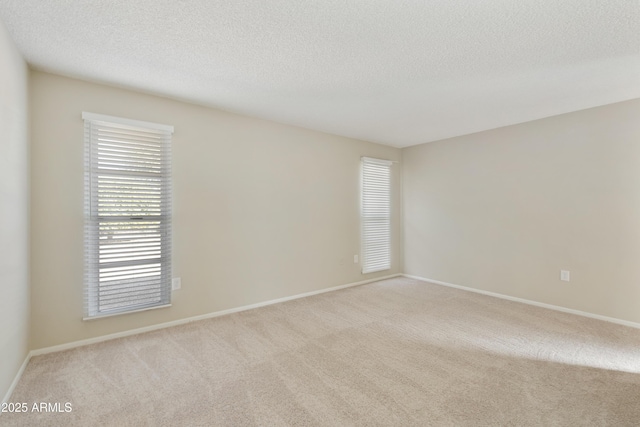 carpeted spare room with a textured ceiling