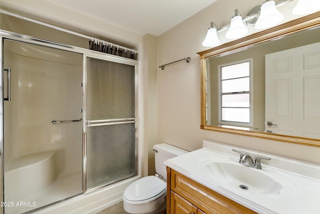 bathroom with vanity, toilet, and a shower with shower door