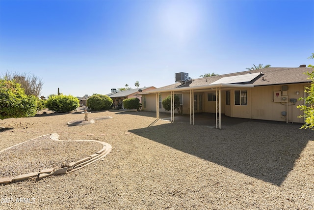 rear view of house featuring solar panels and central air condition unit