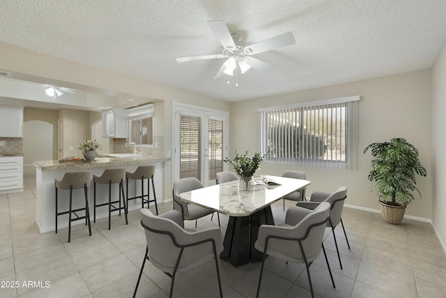 tiled dining room featuring ceiling fan and a textured ceiling