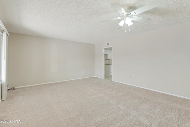 carpeted empty room featuring ceiling fan and a textured ceiling