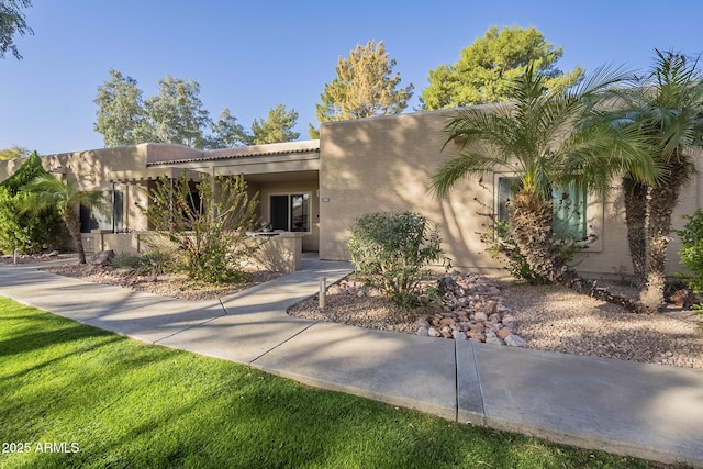 southwest-style home with a front lawn