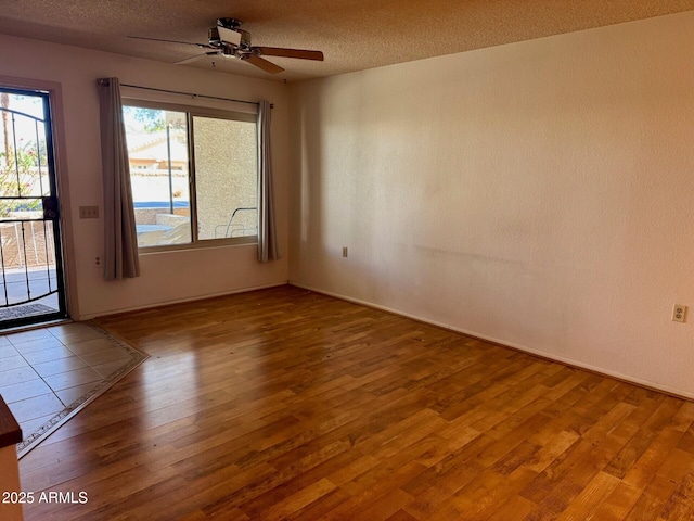 unfurnished room featuring hardwood / wood-style flooring, ceiling fan, and a textured ceiling