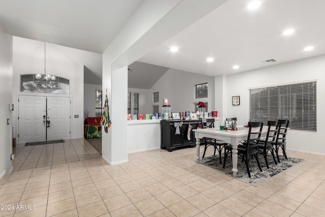 dining area with lofted ceiling, light tile patterned floors, and a chandelier