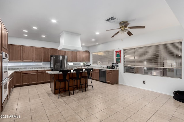 kitchen with stainless steel fridge, a kitchen breakfast bar, sink, dishwasher, and a kitchen island