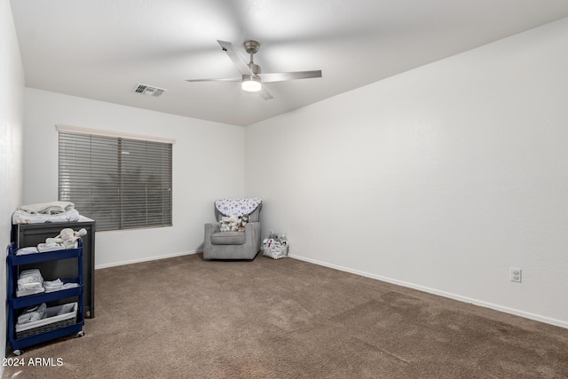 interior space featuring ceiling fan and dark carpet