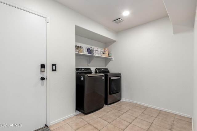 laundry area featuring washer and dryer and light tile patterned floors