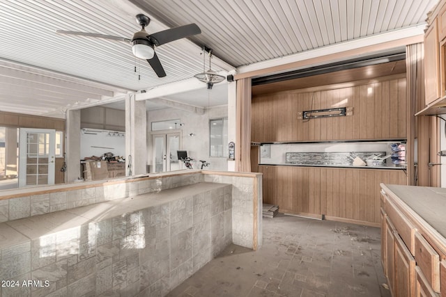 kitchen with ceiling fan and wooden walls