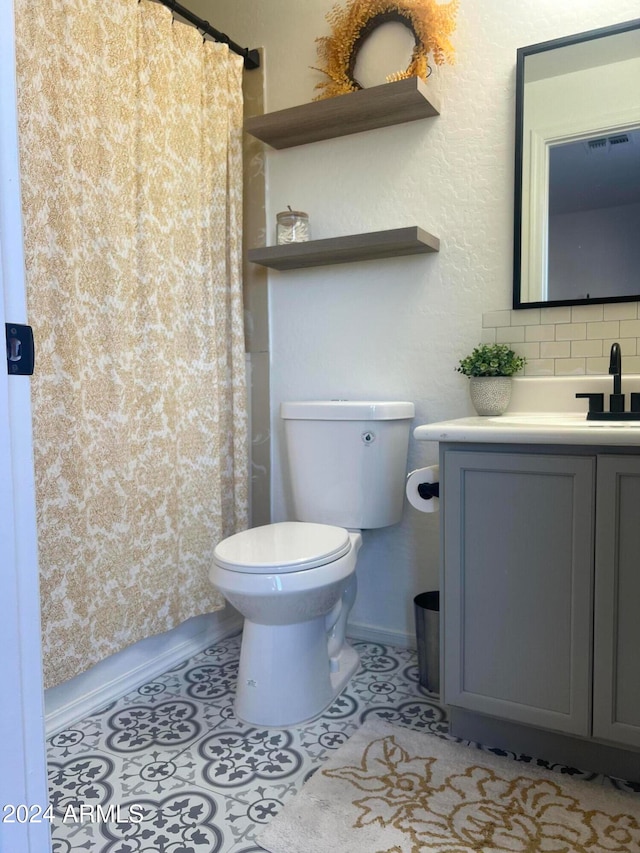 bathroom with tile patterned flooring, vanity, toilet, and backsplash