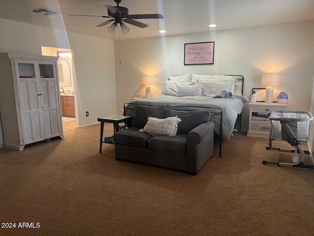 bedroom with ceiling fan, carpet floors, and ensuite bath