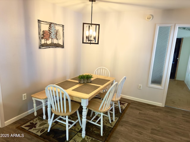 dining room featuring dark hardwood / wood-style floors and an inviting chandelier