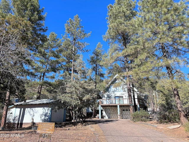 view of front facade featuring a wooden deck and a garage