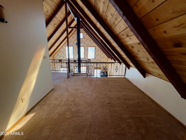 additional living space featuring vaulted ceiling with beams, wooden ceiling, and carpet flooring