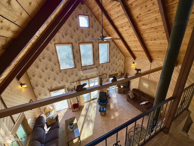 interior space featuring beamed ceiling, ceiling fan, and wooden ceiling