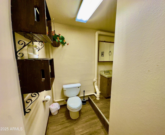 bathroom with hardwood / wood-style flooring and toilet