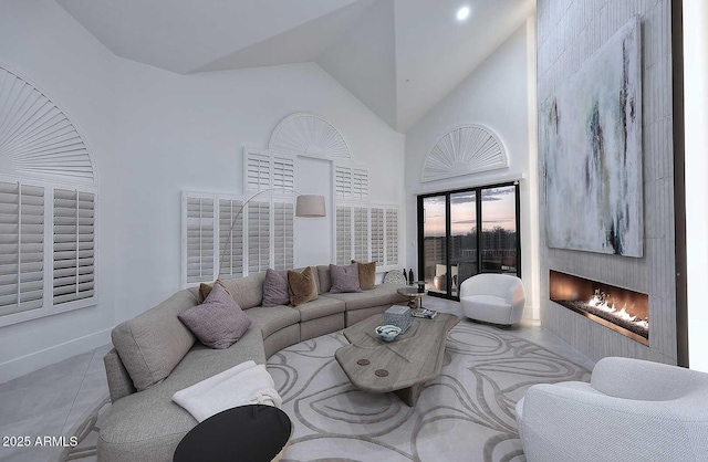 living room with a fireplace and high vaulted ceiling