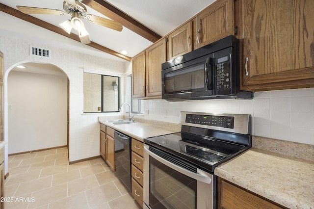 kitchen with brown cabinets, visible vents, a sink, beamed ceiling, and black appliances