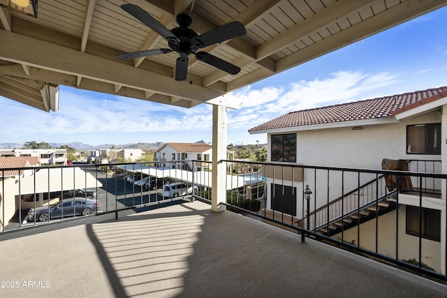 balcony with stairs, a residential view, and a ceiling fan