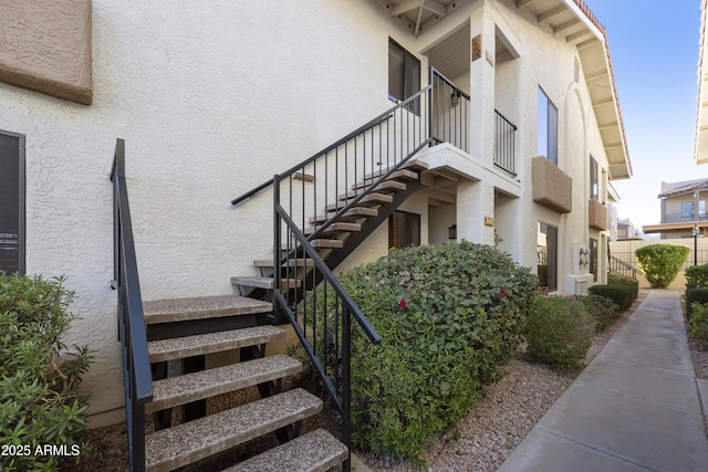 view of home's exterior with stairs and stucco siding