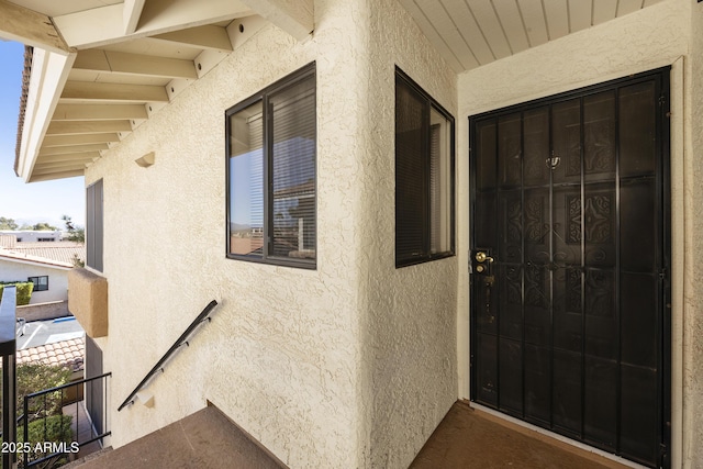 doorway to property featuring a balcony and stucco siding