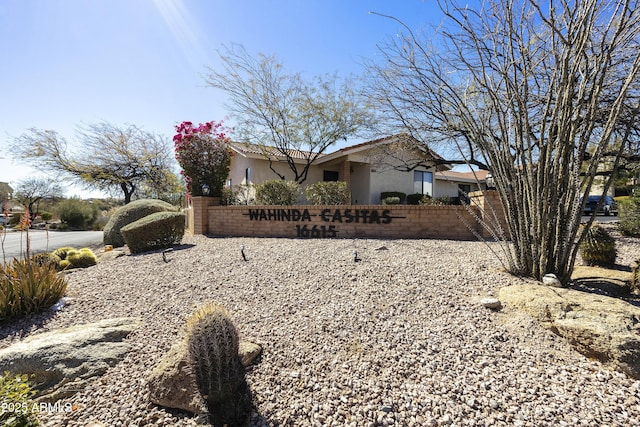 view of front facade featuring fence and stucco siding