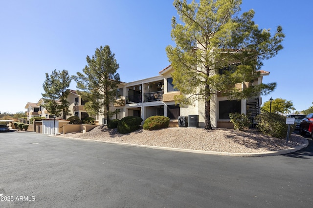 view of front of home featuring a residential view, central AC, and stucco siding