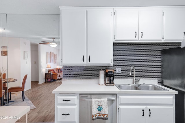 kitchen featuring white cabinetry, stainless steel dishwasher, a sink, light countertops, and light wood finished floors