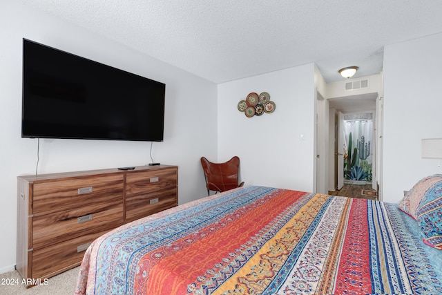 bedroom with carpet floors and a textured ceiling