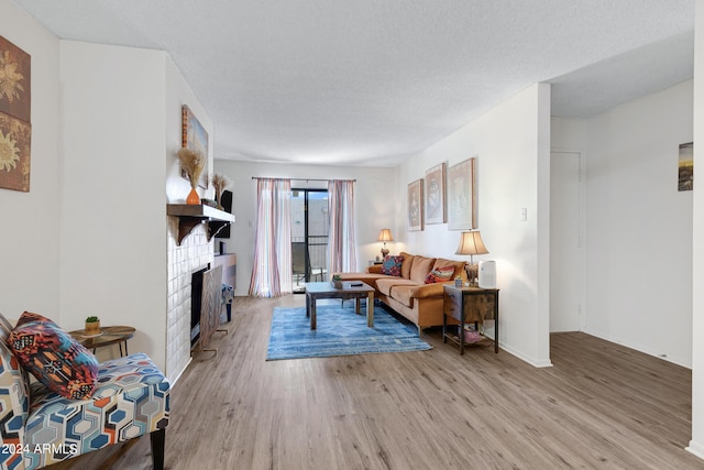 living room featuring a fireplace, light wood-style floors, and baseboards