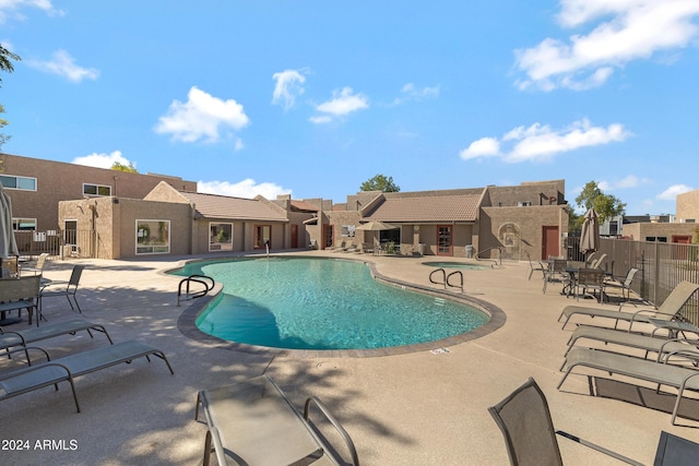 community pool with fence and a patio area
