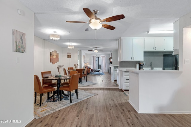 dining room with light wood finished floors, a textured ceiling, ceiling fan, and baseboards