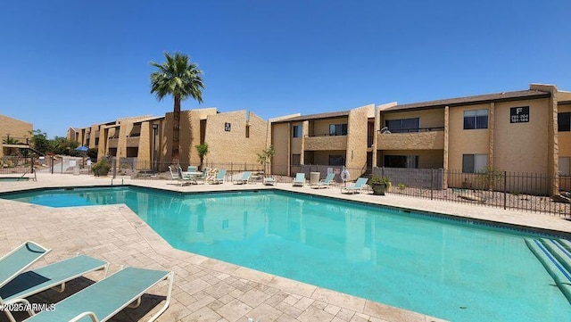 pool with fence and a patio