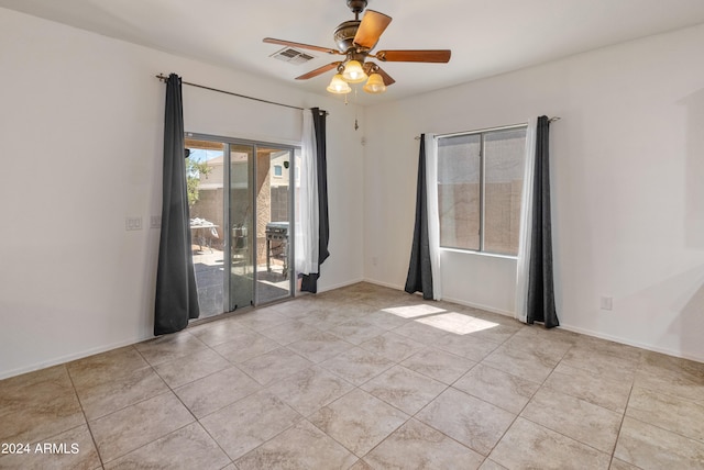 tiled spare room featuring ceiling fan