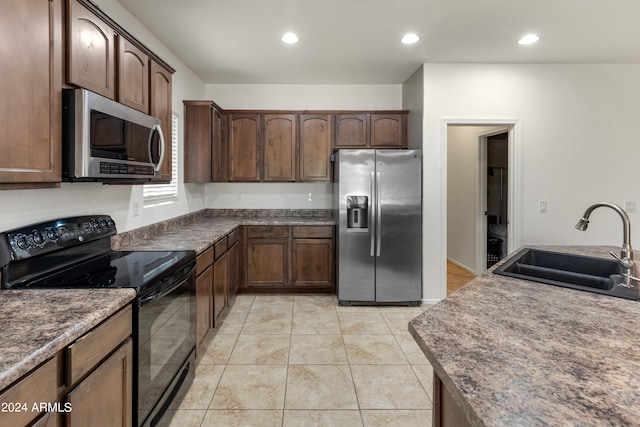 kitchen featuring light tile patterned flooring, appliances with stainless steel finishes, and sink