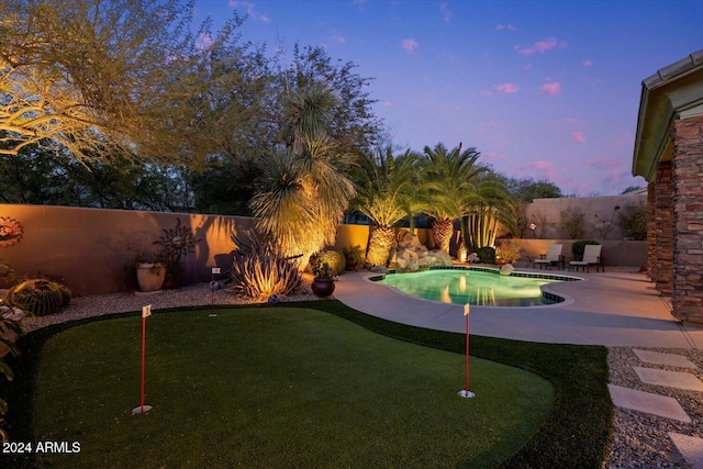 yard at dusk with a fenced in pool and a patio