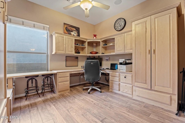 home office featuring light wood-type flooring, built in desk, and ceiling fan