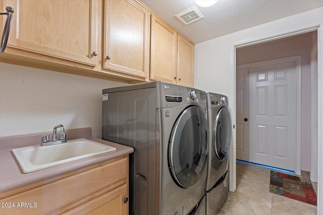 washroom featuring separate washer and dryer, sink, and cabinets