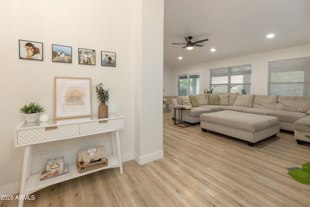 living room featuring ceiling fan and light wood-type flooring