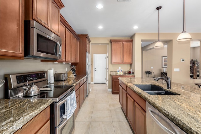 815 E Laddoos Ave, San Tan Valley, AZ 85140 - kitchen featuring brown cabinetry, appliances with stainless steel finishes, light stone countertops, pendant lighting, and a sink
