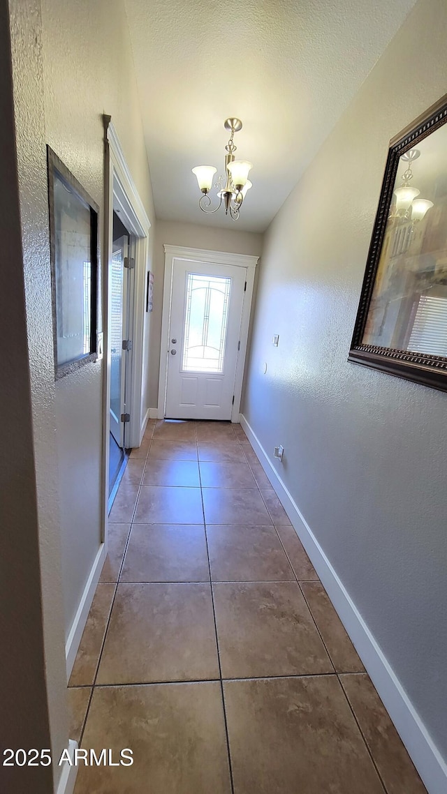 5539 E Dragoon Ave, Mesa, AZ 85206 - doorway to outside with a chandelier, tile patterned flooring, and a textured wall