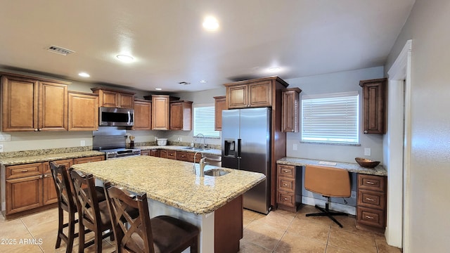 5539 E Dragoon Ave, Mesa, AZ 85206 - kitchen with appliances with stainless steel finishes, a center island with sink, light tile patterned floors, built in study area, and recessed lighting