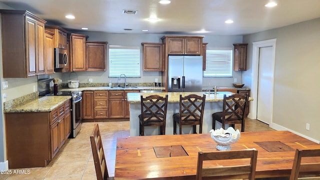 5539 E Dragoon Ave, Mesa, AZ 85206 - kitchen with stainless steel appliances, light tile patterned floors, a kitchen island, recessed lighting, and light stone counters