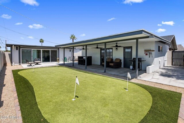 7707 E Earll Dr, Scottsdale, AZ 85251 - rear view of house featuring a putting green, ceiling fan, a patio, and a fenced backyard