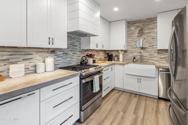 7707 E Earll Dr, Scottsdale, AZ 85251 - kitchen featuring appliances with stainless steel finishes, a sink, custom range hood, light countertops, and backsplash