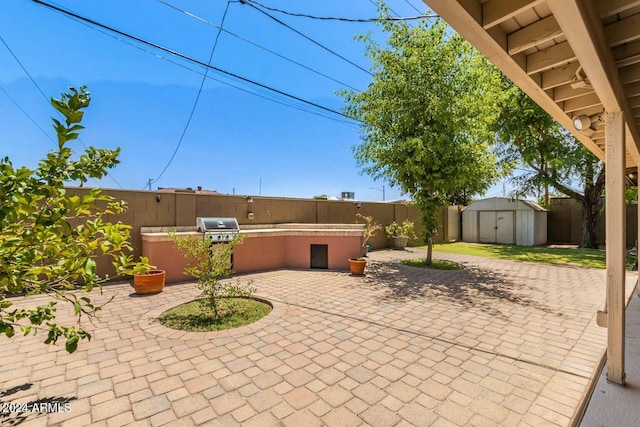 view of patio with area for grilling and a storage shed